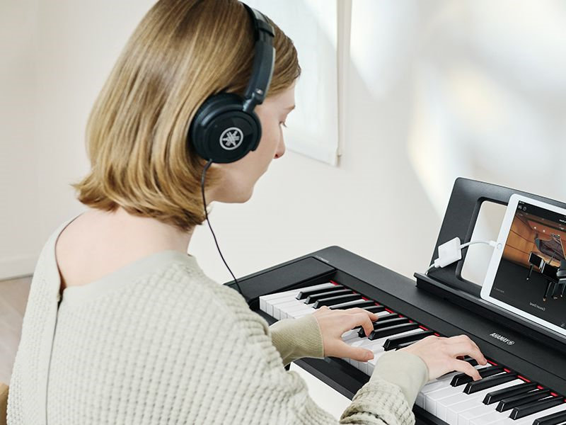 A person using headphones while practicing on the Piaggero