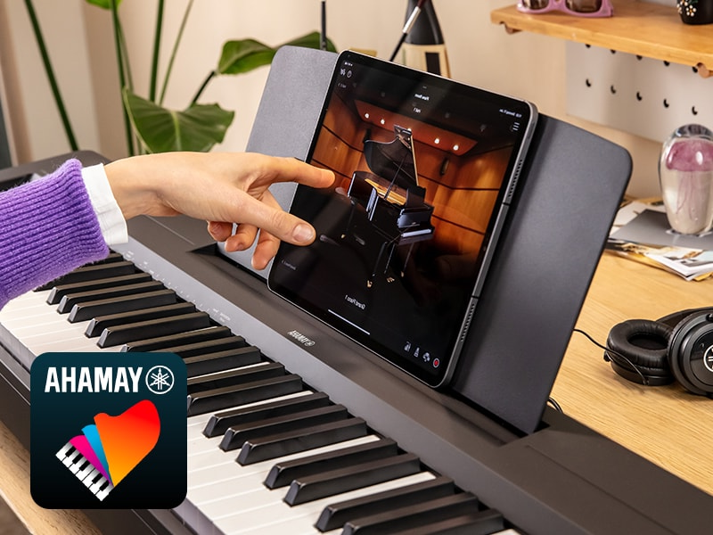 The Yamaha “Smart Pianist” app icon, together with a tablet placed on the music stand of the P-143