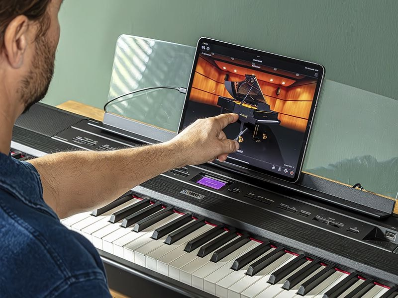The Yamaha “Smart Pianist” app icon, together with a tablet placed on the music stand of the P-525